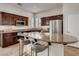 Gourmet kitchen with dark cabinetry, granite countertops, stainless steel appliances, and a breakfast bar for casual dining at 1973 Ardilea St, Las Vegas, NV 89135