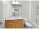 Bright bathroom with white tile, wooden vanity, and large mirror at 2052 Powder Springs St, Henderson, NV 89052