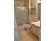Bathroom featuring tub with shower and glass doors, single sink vanity, and neutral walls at 221 Oro Canyon St, Henderson, NV 89074