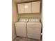 Cozy laundry area features a stacked washer and dryer and upper cabinets for storage solutions at 221 Oro Canyon St, Henderson, NV 89074