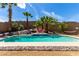 Beautiful backyard oasis with a sparkling pool, rock accents, and lush palm trees for a tranquil escape at 231 Pioneers Peak Ave, Henderson, NV 89002