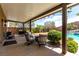 Covered patio with chairs, grill, and a view of the pool in backyard at 231 Pioneers Peak Ave, Henderson, NV 89002