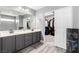 Modern bathroom with double sinks, gray cabinets, and a walk-in closet at 231 Pioneers Peak Ave, Henderson, NV 89002