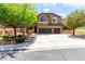 Inviting two-story home with manicured front yard, a concrete driveway, and an attached three-car garage at 231 Pioneers Peak Ave, Henderson, NV 89002