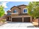 Charming two-story stucco home with a two-car garage and landscaped front yard at 231 Pioneers Peak Ave, Henderson, NV 89002