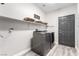 Laundry room with gray washer and dryer, and storage baskets on shelves at 231 Pioneers Peak Ave, Henderson, NV 89002