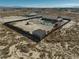 Aerial perspective reveals a pool, manicured grass, and convenient outbuildings, all securely surrounded by the property's fence at 2330 Deadwood St, Pahrump, NV 89048