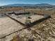 Aerial view of the home featuring a backyard pool, lush grass, and outbuildings surrounded by a secure fenced perimeter at 2330 Deadwood St, Pahrump, NV 89048