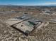 An elevated view shows a pool, grass, and outbuildings inside a fenced yard, within a desert landscape at 2330 Deadwood St, Pahrump, NV 89048
