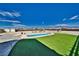 Backyard showcasing a pool, artificial turf, sheds, and mountain views in a serene outdoor setting at 2330 Deadwood St, Pahrump, NV 89048