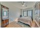 Bright bedroom with wood floors, decorative mirror, plush bed, natural light from the window with privacy blinds at 2330 Deadwood St, Pahrump, NV 89048