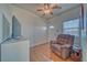 Cozy living room featuring wood-look flooring, a ceiling fan, a TV, a comfortable chair, and a window at 2330 Deadwood St, Pahrump, NV 89048