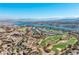 Breathtaking aerial view showcasing a serene lake, golf course, and stunning mountain backdrop at 26 Via Vasari # 204, Henderson, NV 89011