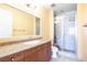 Bathroom featuring a vanity with granite countertop, a framed mirror, and a glass enclosed shower at 26 Via Vasari # 204, Henderson, NV 89011