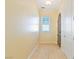 Hallway with tile flooring, arched doorway, window with blinds, and neutral paint at 26 Via Vasari # 204, Henderson, NV 89011