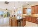 Gourmet kitchen featuring an island, wine fridge, granite countertops, and stainless steel appliances at 26 Via Vasari # 204, Henderson, NV 89011
