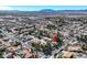 Expansive aerial view showcasing the home in a large community with an industrial area and mountains in the background at 3111 Coachlight Cir, Las Vegas, NV 89117