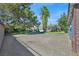 Expansive backyard with a paved driveway leading to the pool area, surrounded by lush greenery and mature trees at 3111 Coachlight Cir, Las Vegas, NV 89117