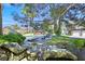 Backyard view of pool, rock waterfall, brick patio and seating areas, complemented by mature trees and landscaping at 3111 Coachlight Cir, Las Vegas, NV 89117