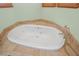 A luxurious bathroom features a jetted tub with tile surround at 3111 Coachlight Cir, Las Vegas, NV 89117