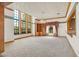 Bright living room featuring large windows, custom shelving, and decorative wallpaper at 3111 Coachlight Cir, Las Vegas, NV 89117