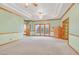 Spacious living room with plush carpeting, tray ceilings, ceiling fans, and natural light from large windows at 3111 Coachlight Cir, Las Vegas, NV 89117