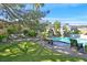Lush backyard with pool, rock waterfall, mature trees and greenery, creating a tranquil retreat at 3111 Coachlight Cir, Las Vegas, NV 89117