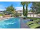 A luxurious backyard featuring a large pool, hot tub, and lounge chairs with palm trees, perfect for relaxation and entertainment at 3111 Coachlight Cir, Las Vegas, NV 89117
