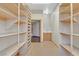 Long walk-in closet with custom shelving, providing ample space for organized storage, and an adjacent utility sink at 3111 Coachlight Cir, Las Vegas, NV 89117