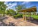A shaded picnic area with tables and benches in a grassy, tree-lined community park at 3281 Pergusa Dr, Henderson, NV 89044
