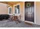 Inviting front porch with chairs, landscaping, and a dark wood front door at 3281 Pergusa Dr, Henderson, NV 89044