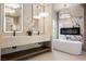 Modern bathroom featuring a double vanity, soaking tub, and a fireplace with marble accents at 501 Proud Eagle Ln, Las Vegas, NV 89144