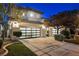 Three car garage of a modern home with manicured landscaping and twilight sky at 501 Proud Eagle Ln, Las Vegas, NV 89144