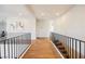 Bright hallway with hardwood floors, staircase, iron railings, and modern artwork on the walls at 501 Proud Eagle Ln, Las Vegas, NV 89144
