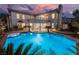 Expansive swimming pool at the rear of an elegant two-story home with manicured landscaping and sunset views at 501 Proud Eagle Ln, Las Vegas, NV 89144