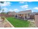 Fenced backyard featuring lawn, covered patio, and mature trees at 5988 Turtle River Ave, Las Vegas, NV 89156