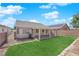 Exterior view of the backyard with covered patio, lawn, and block wall at 5988 Turtle River Ave, Las Vegas, NV 89156