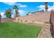 Large backyard has a well-kept lawn, block wall, and desert landscaping at 5988 Turtle River Ave, Las Vegas, NV 89156