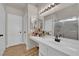 Bright bathroom features a white vanity with a built-in makeup station, modern fixtures, and a glass-enclosed shower at 5988 Turtle River Ave, Las Vegas, NV 89156