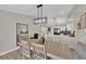 Open dining area with wood floors, modern chandelier, and sightlines to kitchen at 5988 Turtle River Ave, Las Vegas, NV 89156
