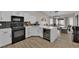 Stylish kitchen boasts white cabinets, sleek black appliances, and a spacious island, perfect for cooking and entertaining at 5988 Turtle River Ave, Las Vegas, NV 89156