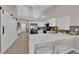 Open-concept kitchen with white cabinets, stainless steel refrigerator, and an inviting breakfast bar, creating a functional area at 5988 Turtle River Ave, Las Vegas, NV 89156