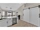 Modern kitchen with a beverage cooler, bar seating, and barn doors, offers a perfect blend of style and functionality at 5988 Turtle River Ave, Las Vegas, NV 89156