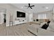 Cozy living room features a ceiling fan, TV, and wood-look flooring at 5988 Turtle River Ave, Las Vegas, NV 89156
