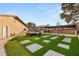 Backyard oasis with artificial turf, stepping stones, covered patio and lounge area, offering a modern and stylish outdoor space at 6975 Darby Ave, Las Vegas, NV 89117