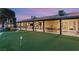 Expansive backyard features a covered patio, outdoor kitchen, and mini golf course for endless entertainment at 6975 Darby Ave, Las Vegas, NV 89117