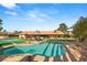 Stunning backyard with a sparkling pool, a tennis court, and lush landscaping, perfect for outdoor living and recreation at 6975 Darby Ave, Las Vegas, NV 89117