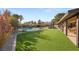 Expansive backyard with putting green, pool, lounge area, and covered patio with outdoor kitchen, perfect for entertaining at 6975 Darby Ave, Las Vegas, NV 89117