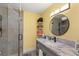 Well-lit bathroom with a gray vanity, sink, and a shower with glass door at 6975 Darby Ave, Las Vegas, NV 89117