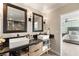 Stylish bathroom with double sinks, framed mirrors, and easy access to main bedroom and the shower at 6975 Darby Ave, Las Vegas, NV 89117